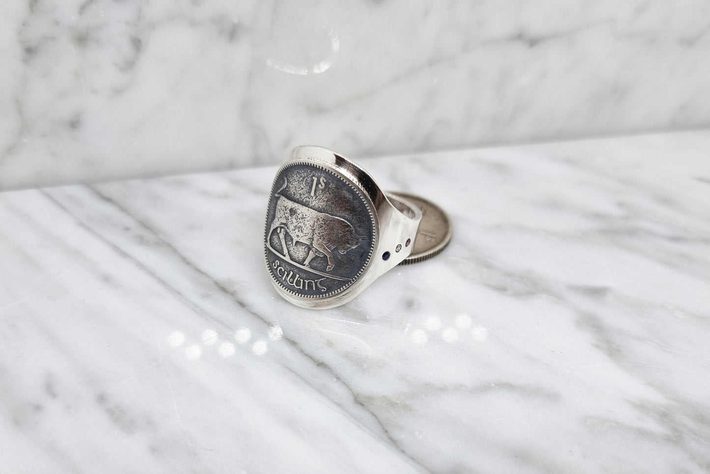 Bague chevalière pièce de monnaie de 1 shilling d'Irlande cintrée en argent serti d'un saphir, d'un diamant et d'un rubis avec gravure.